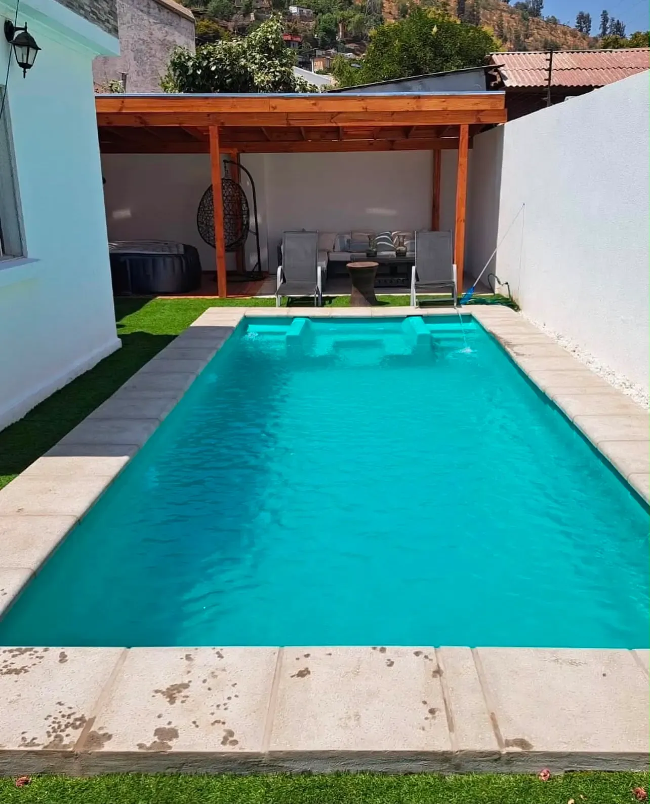 Piscina con pérgola y borde continuo, instalada por Piscinas HH